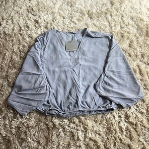 loose mid length top with elastic at bottom, v- neck, and half arm sleeve